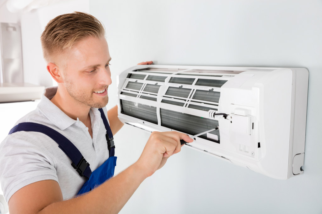 HVAC technician performing ductless air conditioning maintenance in West Valley City