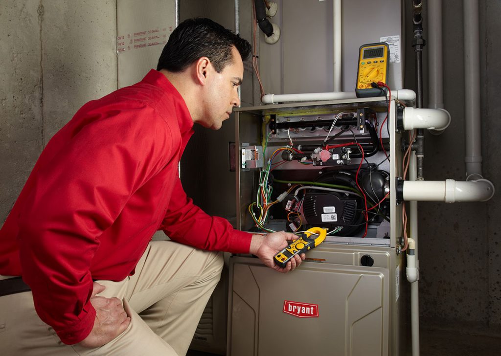 HVAC technician repairing an indoor furnace in West Valley City