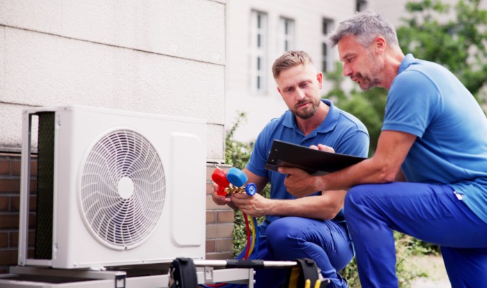 HVAC technicians installing an outdoor air conditioning unit in West Valley City