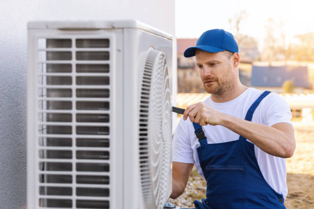 HVAC technician servicing an outdoor air conditioning unit in West Valley City