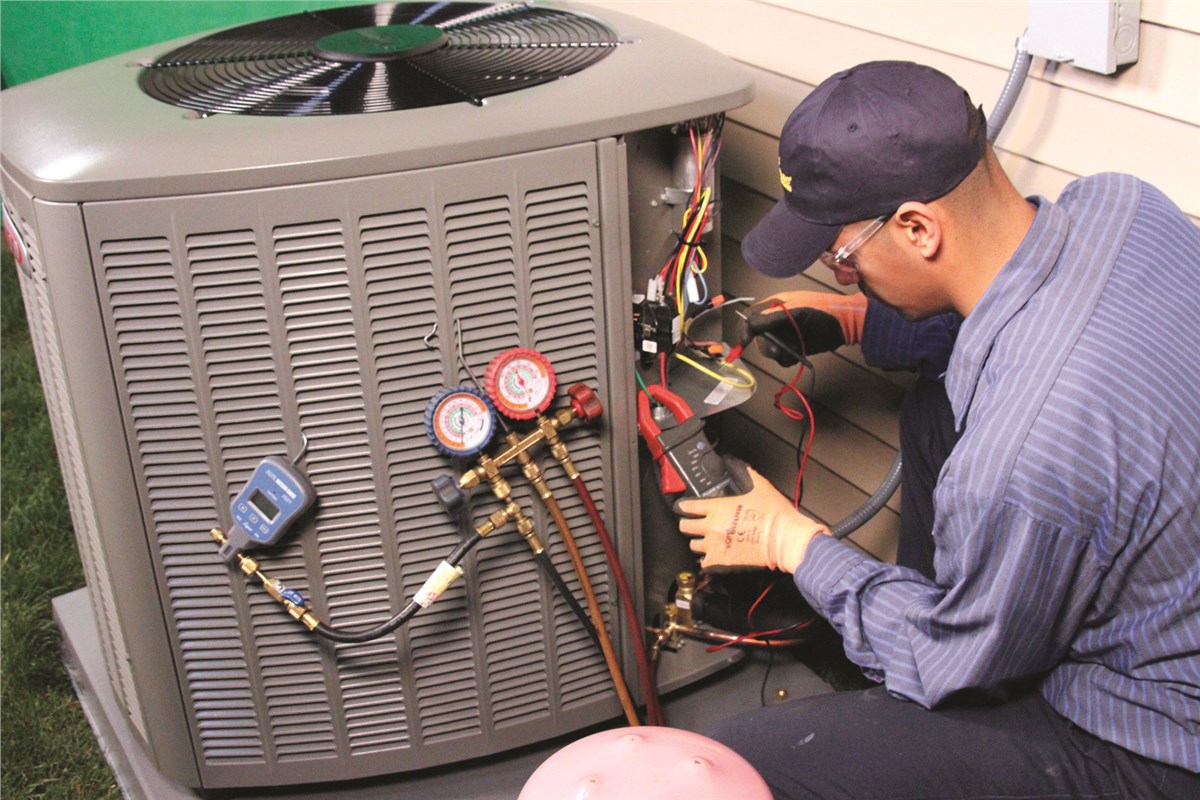 HVAC technician testing an outdoor air conditioning unit in West Valley City