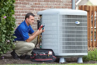 design-air-heating-and-air-conditioning-decatur-il-05 – Copy HVAC technician inspecting an outdoor air conditioning unit in West Valley City, UT